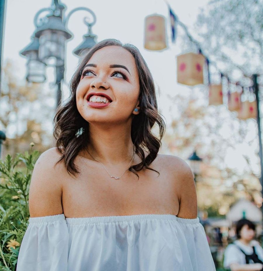 woman smiling at the sky under tangled lanterns at walt disney world