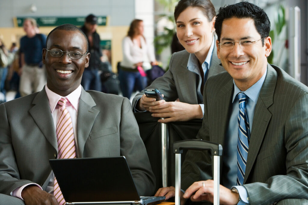 two business men and a business woman working in an airport lobby