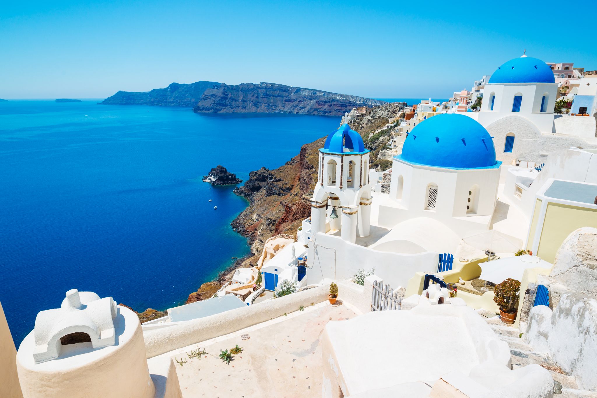 aerial shot of white villas with blue domes in Santorini Island Greece