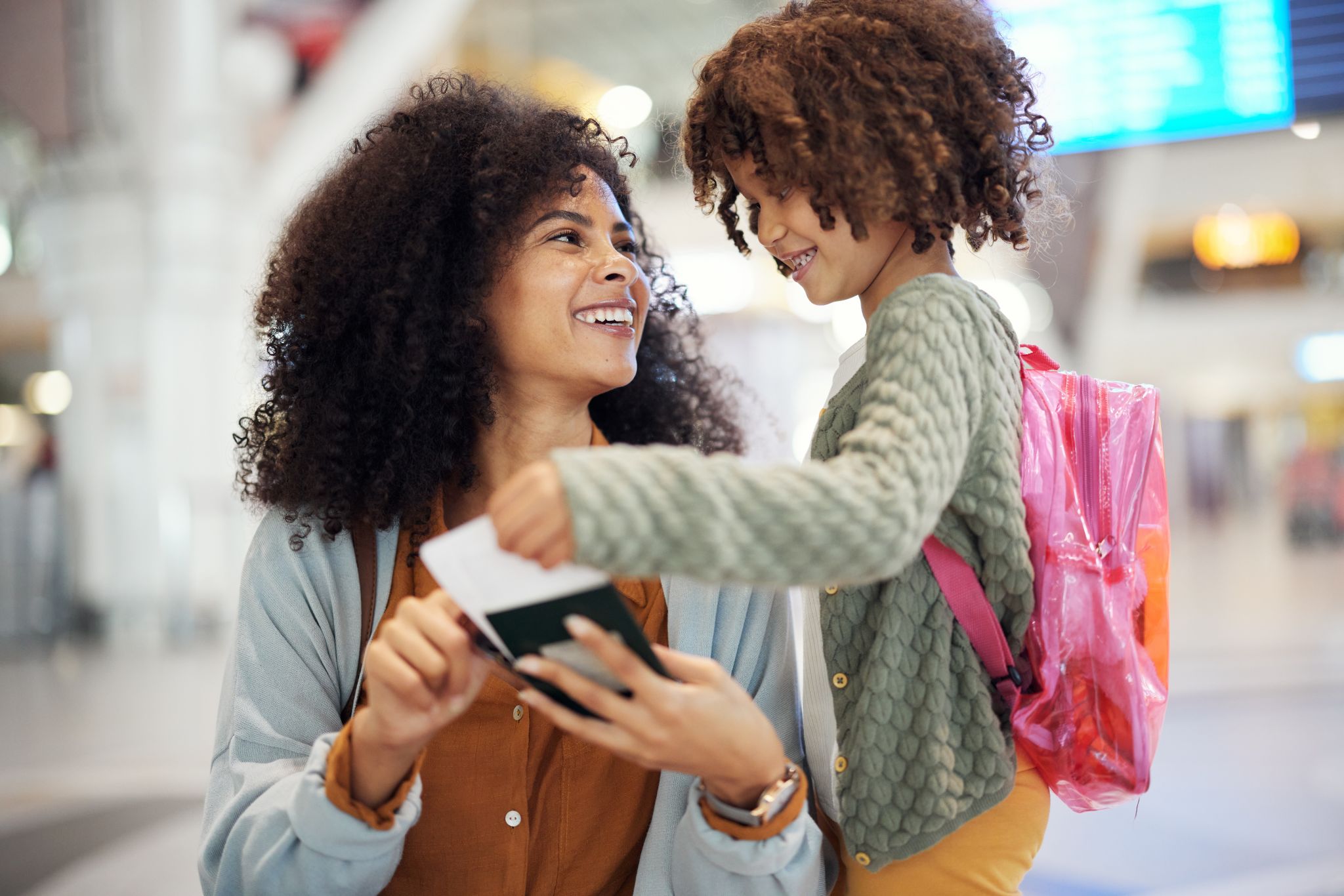 young woman and daughter with passport and boarding pass in an airport